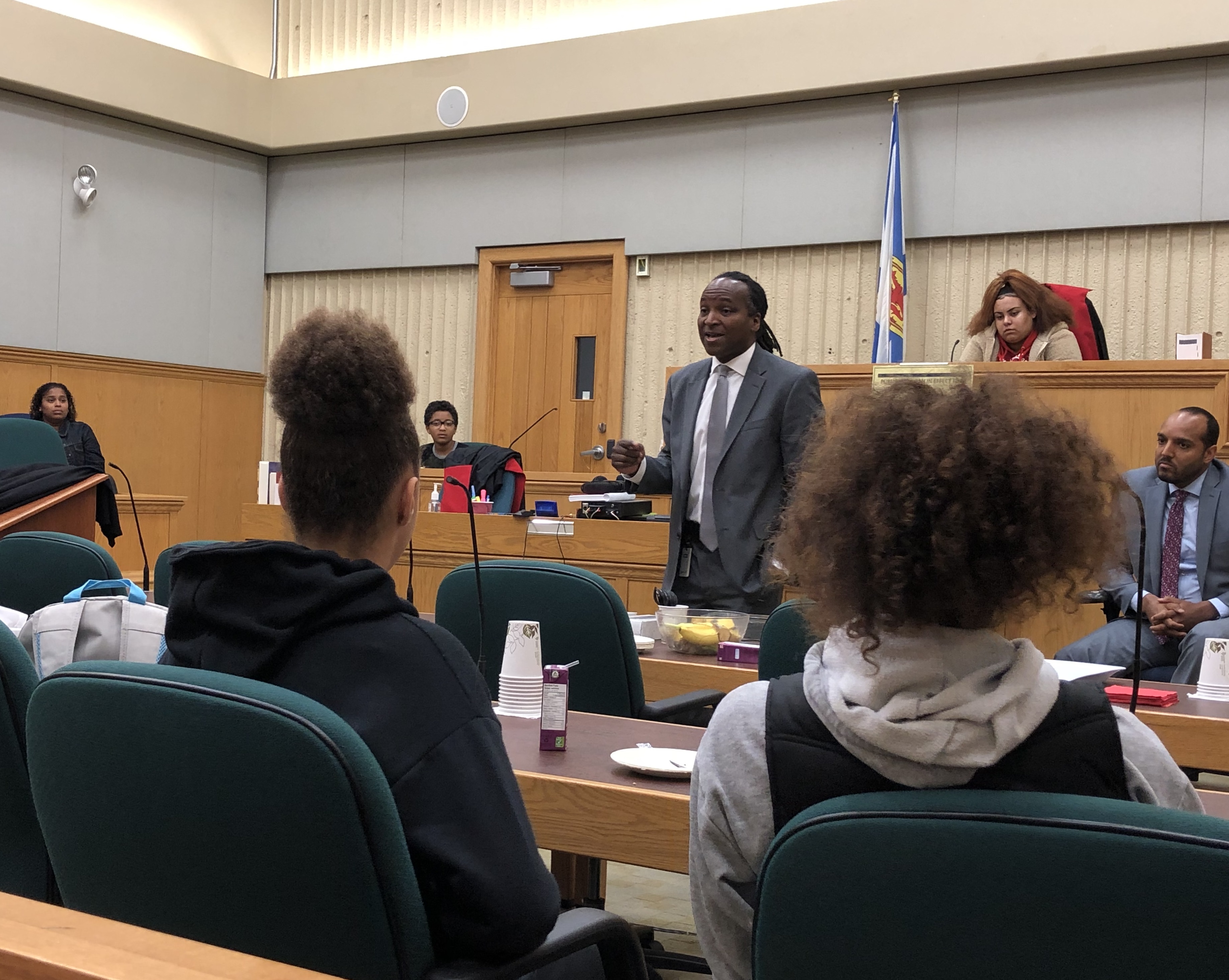 A Crown Attorney talks to students in a courtroom.