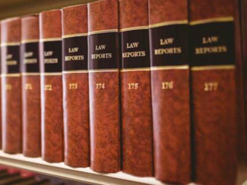 Hardcover legal books on a bookshelf. 