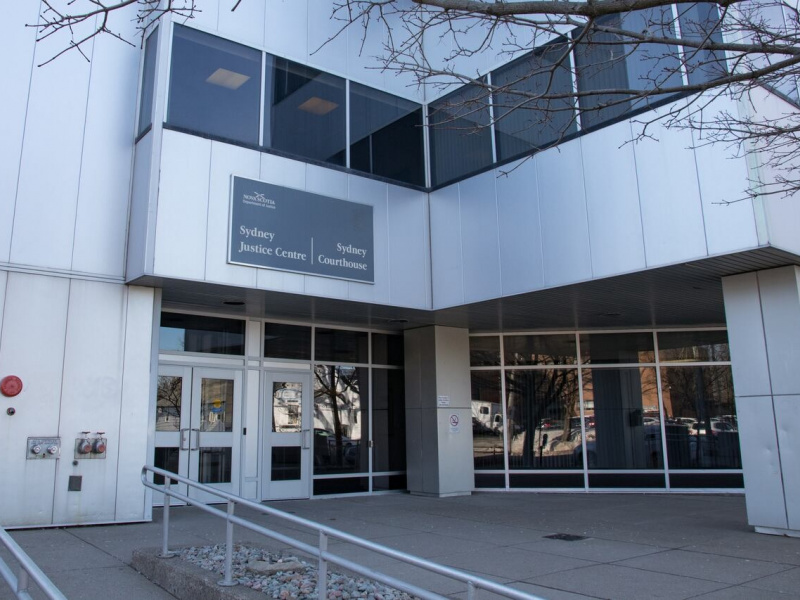 Large white professional building with a courthouse sign above the door.