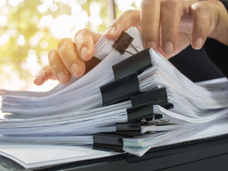 Hands sifting through a stack of legal documents.