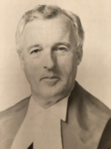 Black and white photo of a judge in robes.