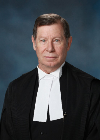 White man in black and white judicial robes. 