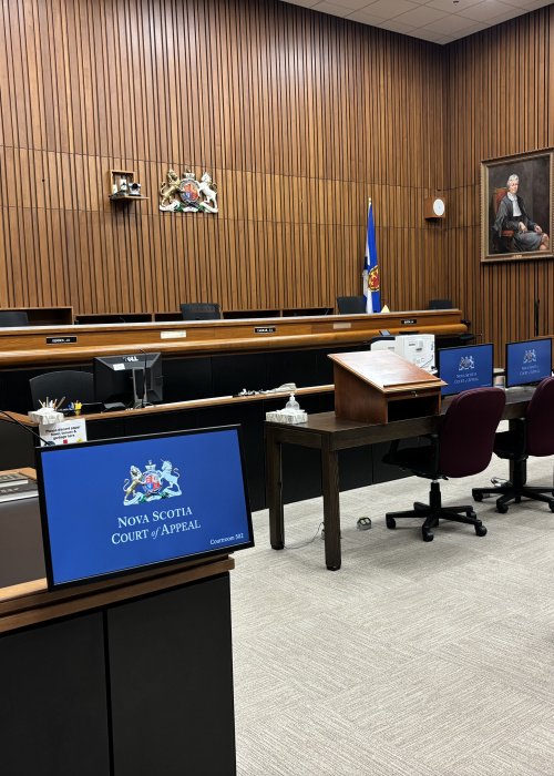 A photo of a Nova Scotia Court of Appeal courtroom. The computer screens show the Court's emblem and the words Nova Scotia Court of Appeal.