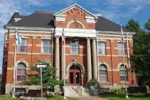 Large red brick building with pillars at the front entrance. 